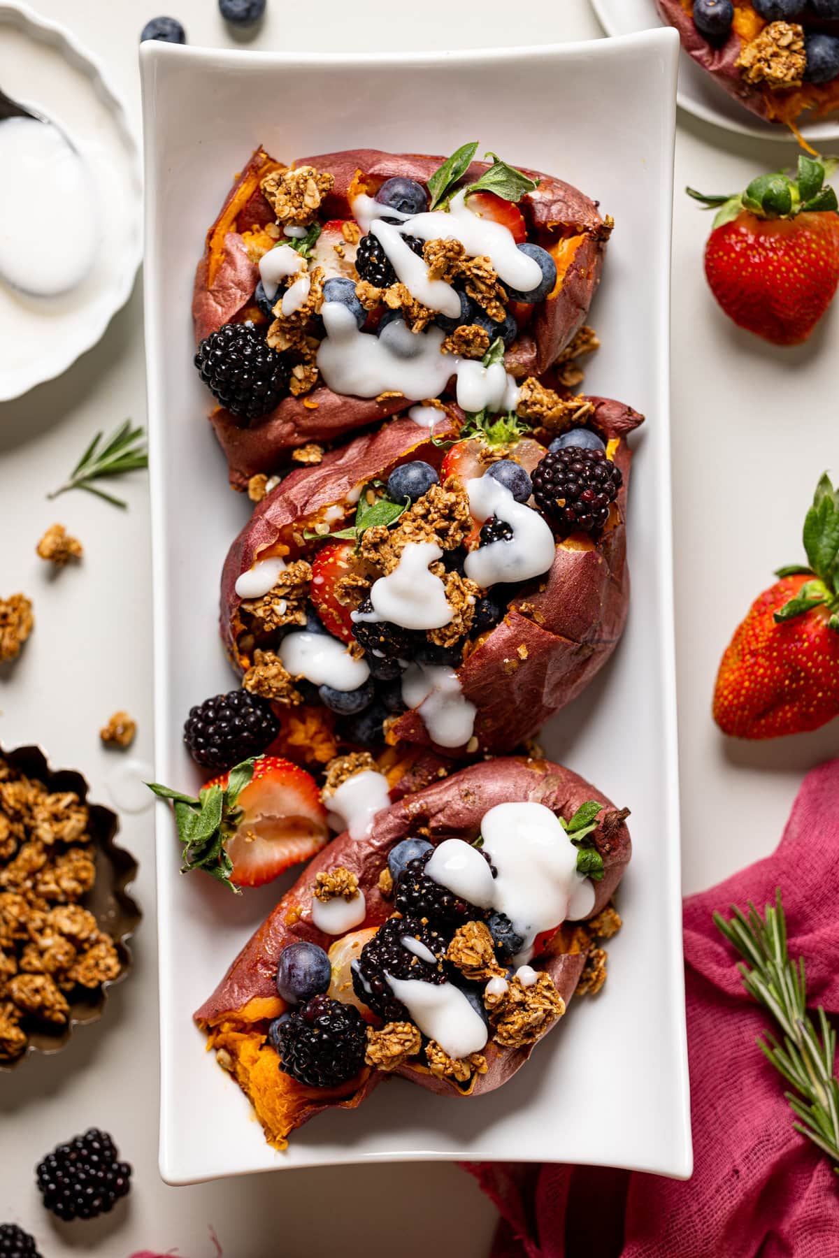 Plate with three sweet potato berry breakfast boats drizzled with yogurt