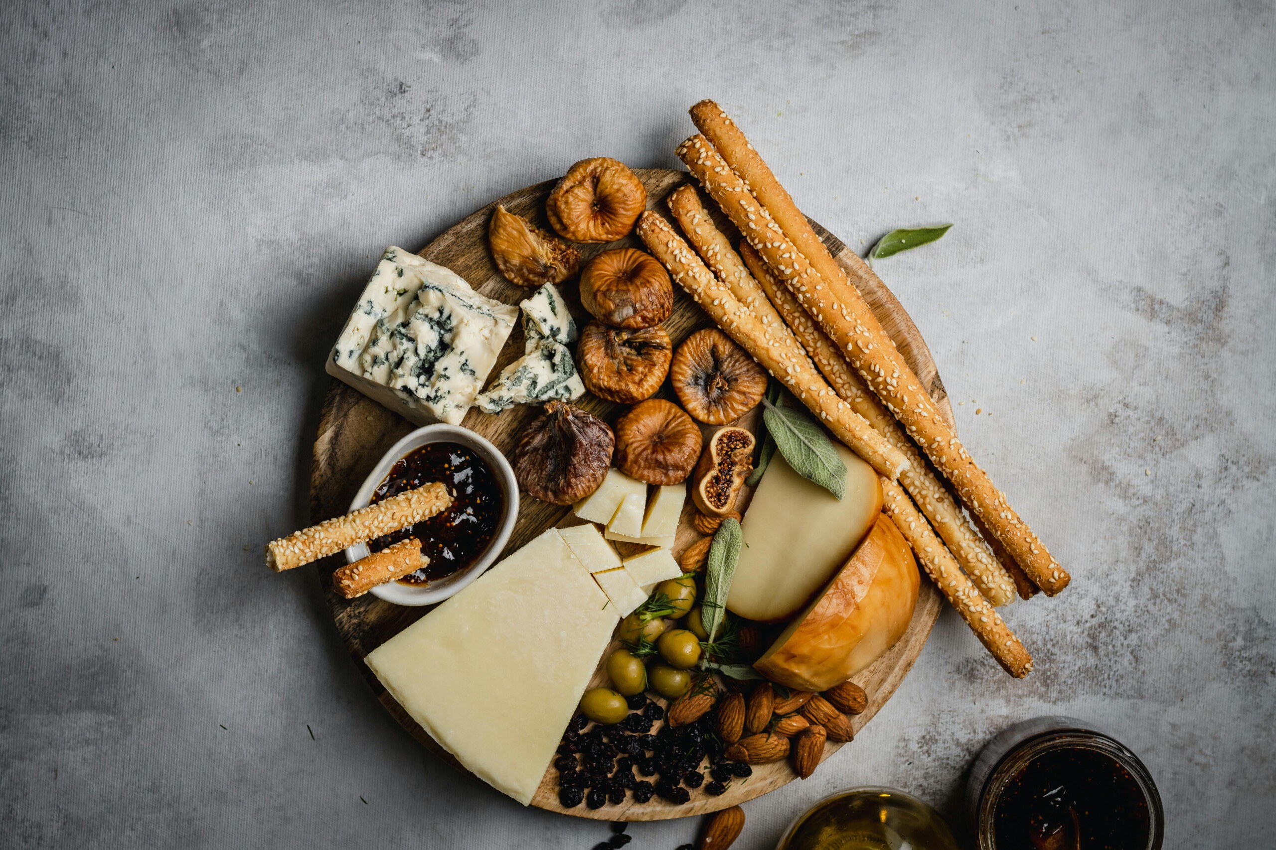 Image of a cheeseboard with snacks on a slate table.
