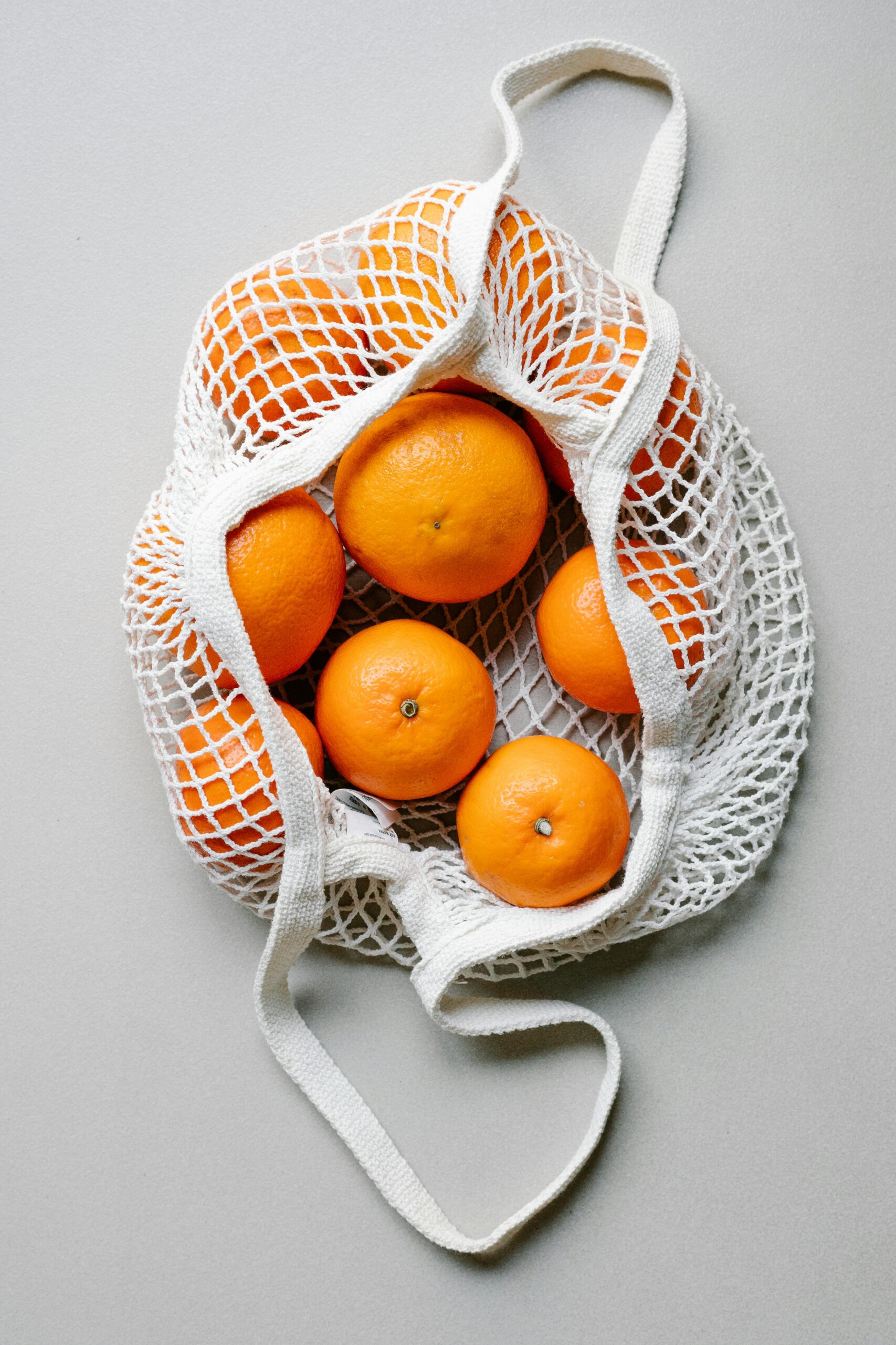 Image of a grocery bag filled with oranges. 