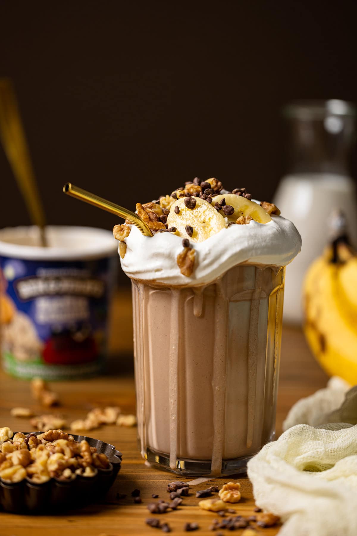 Overflowing glass of Peanut Butter Chunky Monkey Milkshake