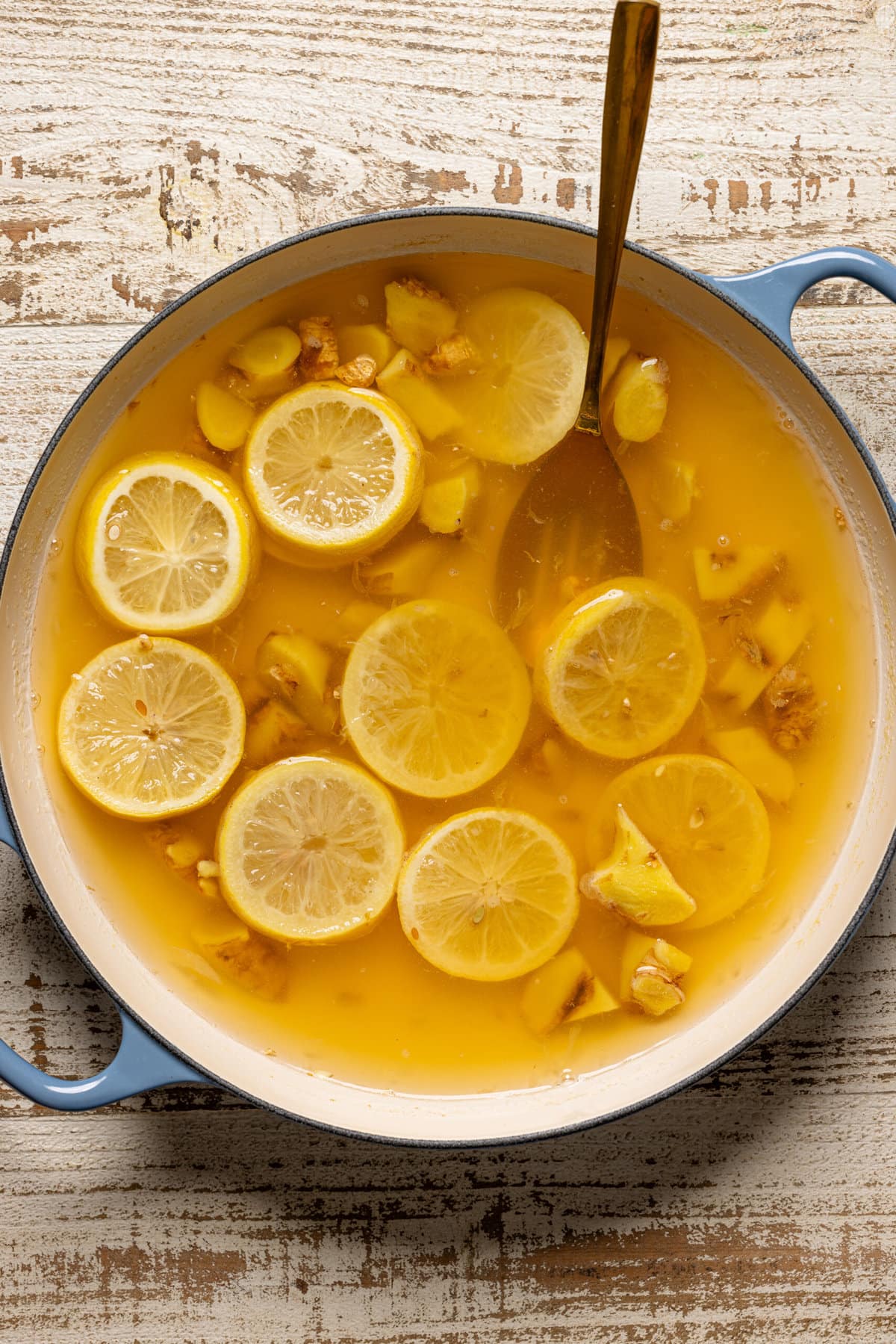 Lemon and ginger boiled in a large pot with water and spoon.