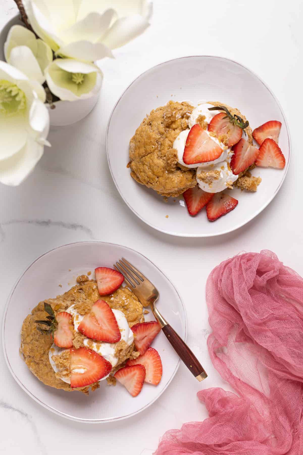 Maple Whole Wheat Oatmeal Strawberry Shortcake on a white plate with a white flour in the background and pink gauze.