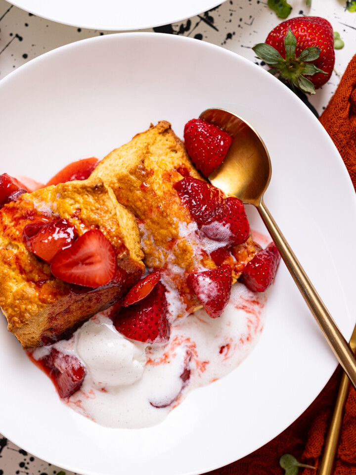 Up close shot of My Fave Strawberry Shortcake Biscuits on a white plate with a spoon.