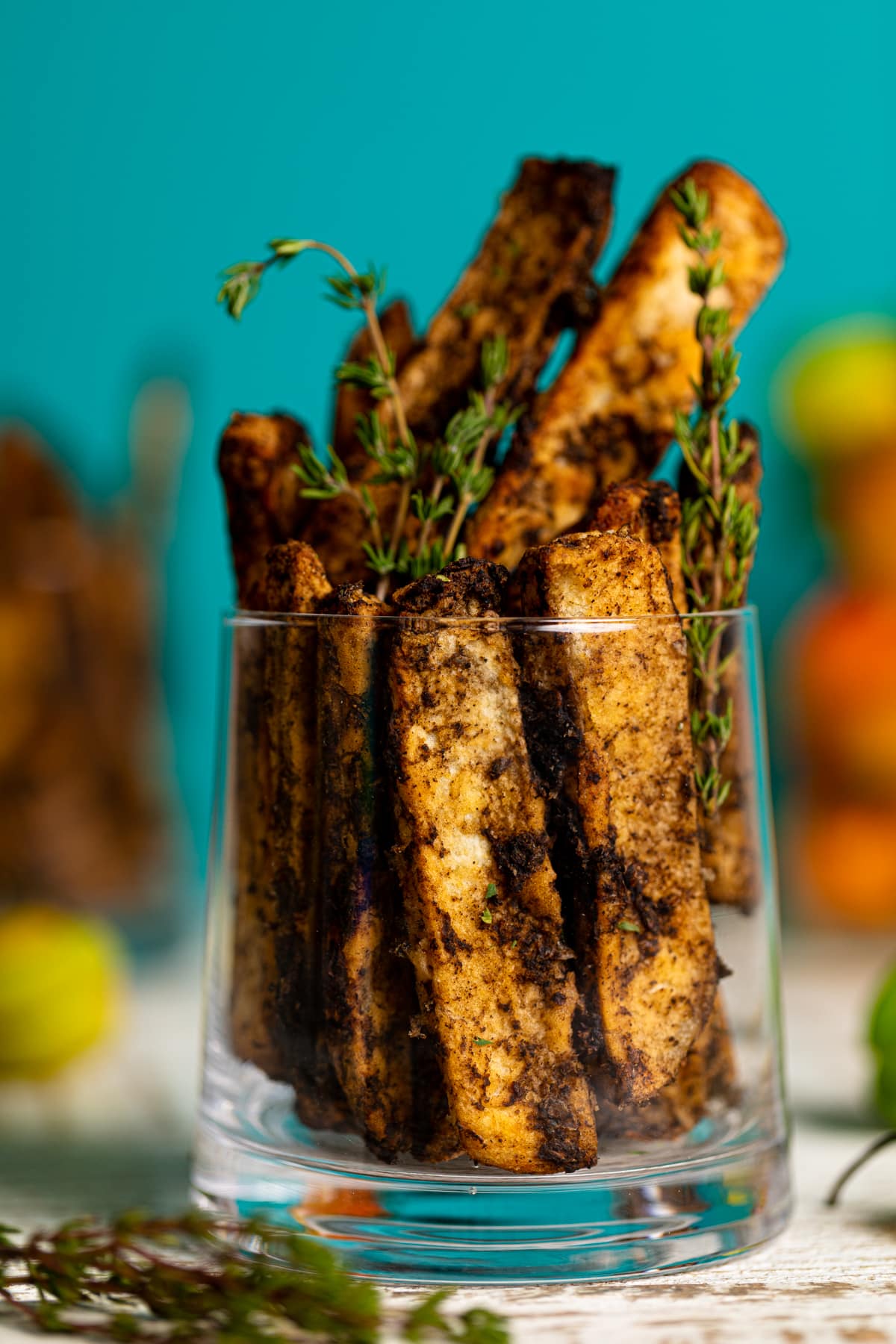 Closeup of a glass stuffed with Crispy Baked Jerk Potato Wedges