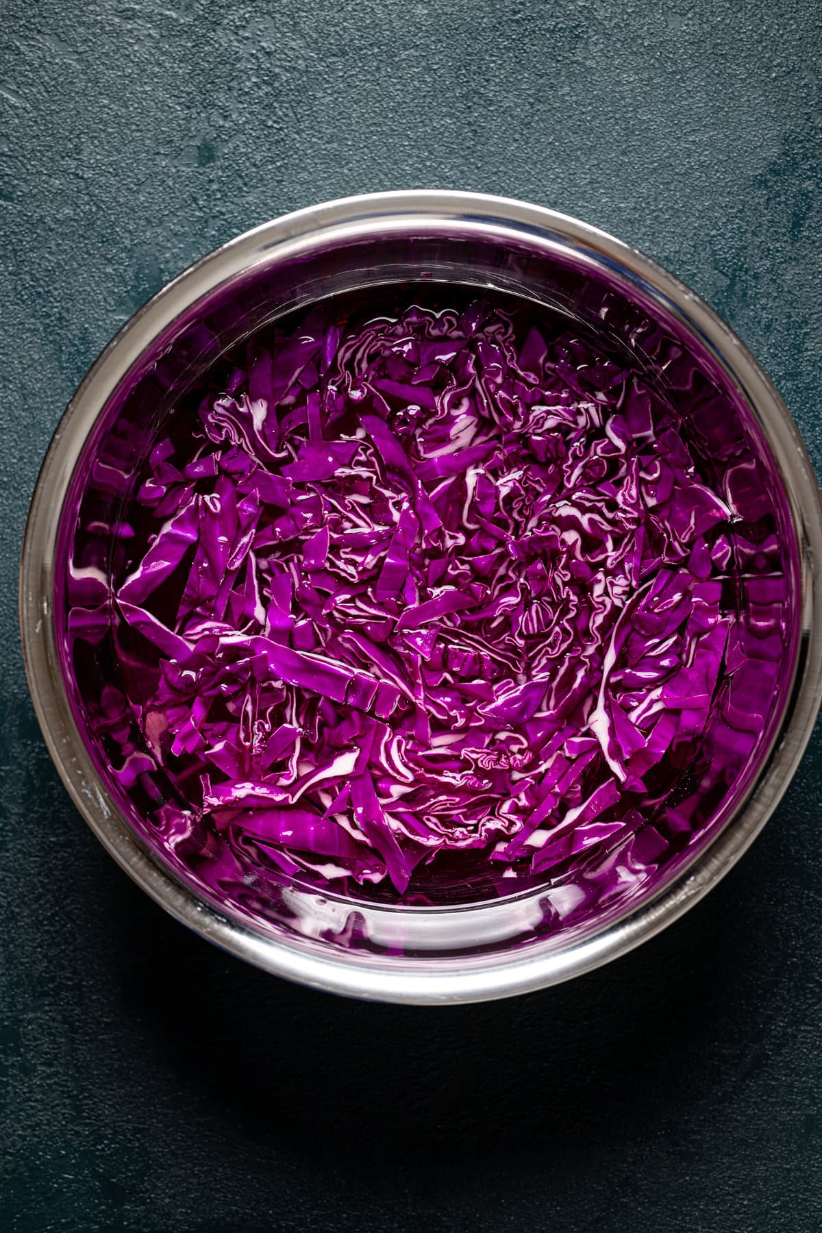 Shredded purple cabbage and water in a bowl