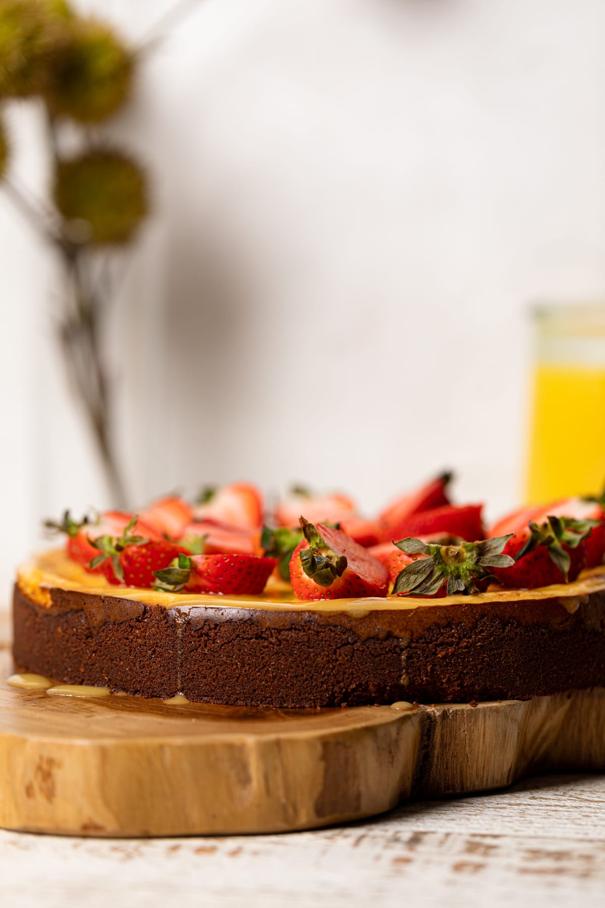 Mango Cheesecake with Chocolate Graham Cracker Crust on a wooden board.