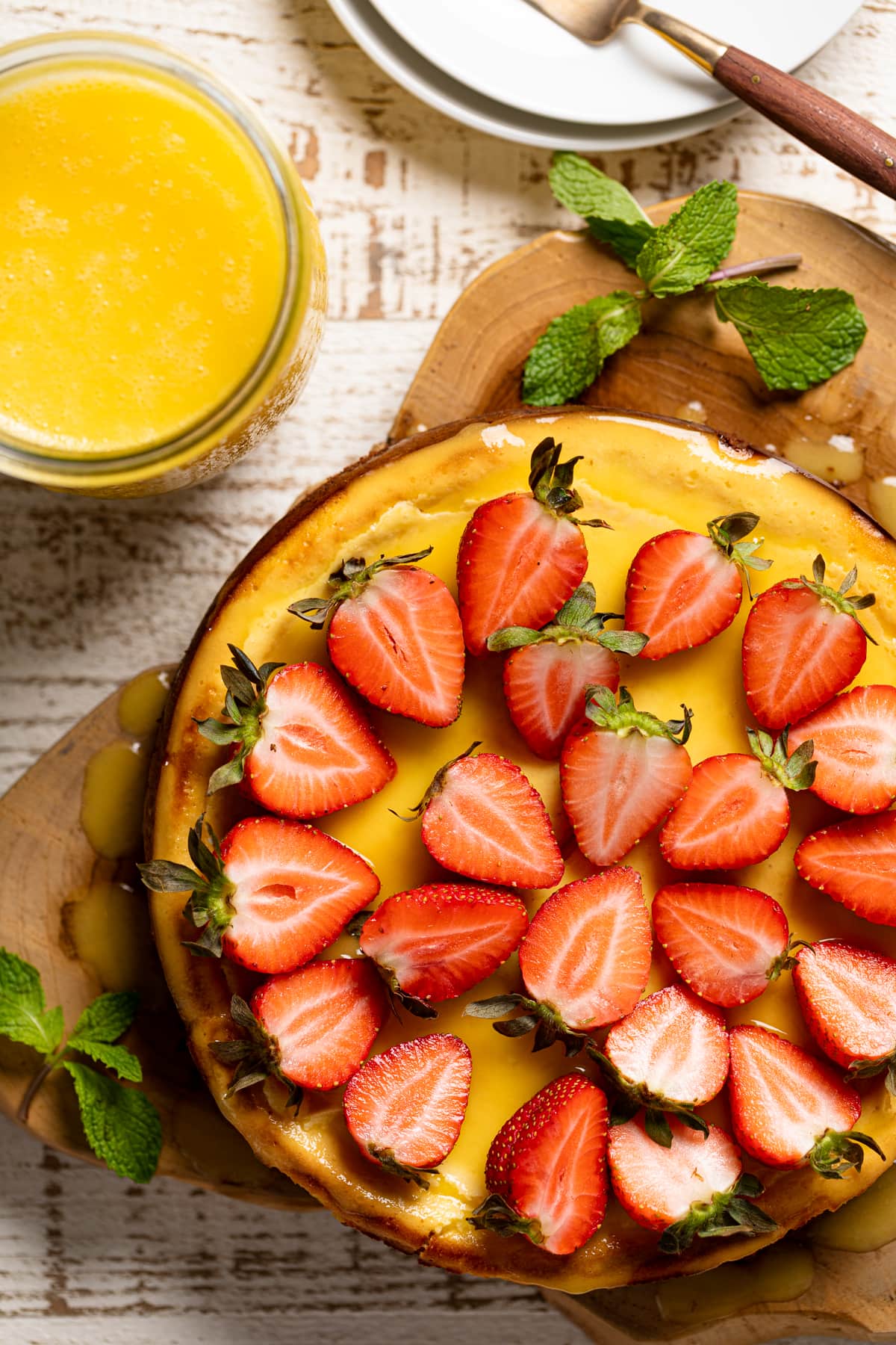 Halved strawberries atop a Mango Cheesecake with Chocolate Graham Cracker Crust.