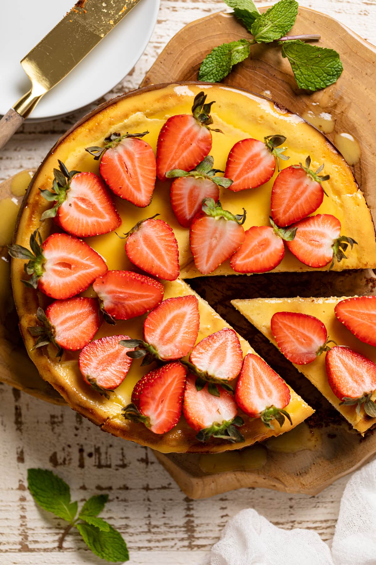 Slice being removed from a Mango Cheesecake with Chocolate Graham Cracker Crust.