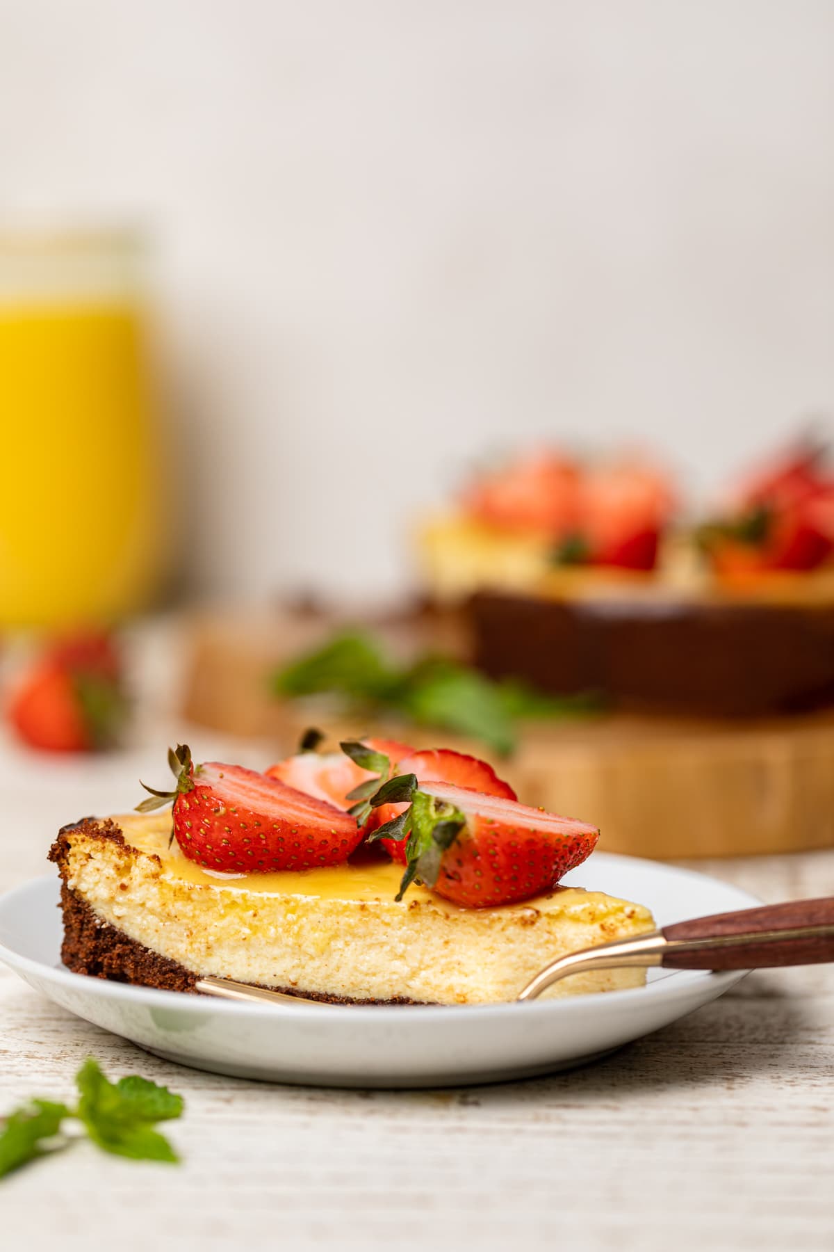 Slice of Mango Cheesecake with Chocolate Graham Cracker Crust on a small plate.