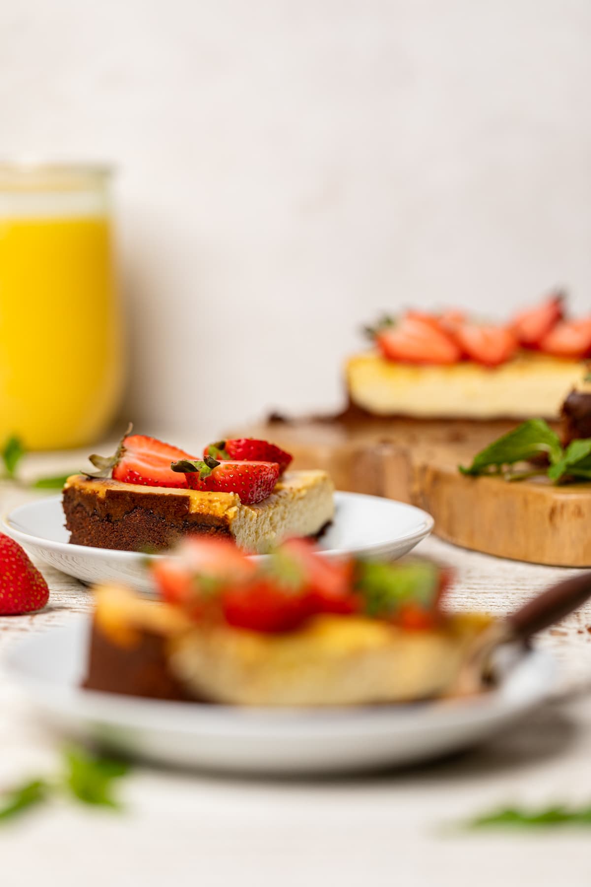 Slices of Mango Cheesecake with Chocolate Graham Cracker Crust on small plates.