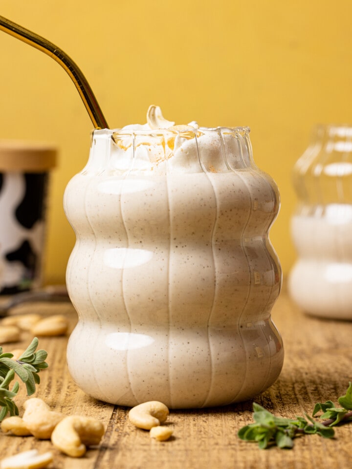 Up close shot of shake in a glass with herbs and cashews.