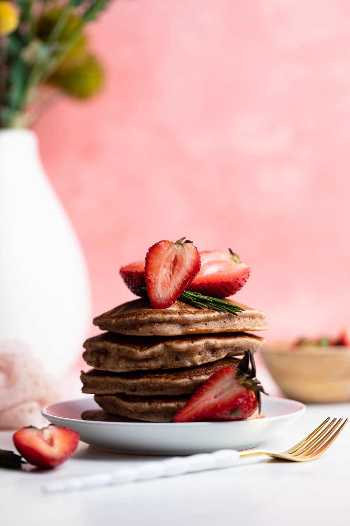 Whole Wheat Strawberry Pancakes topped with sliced strawberries.