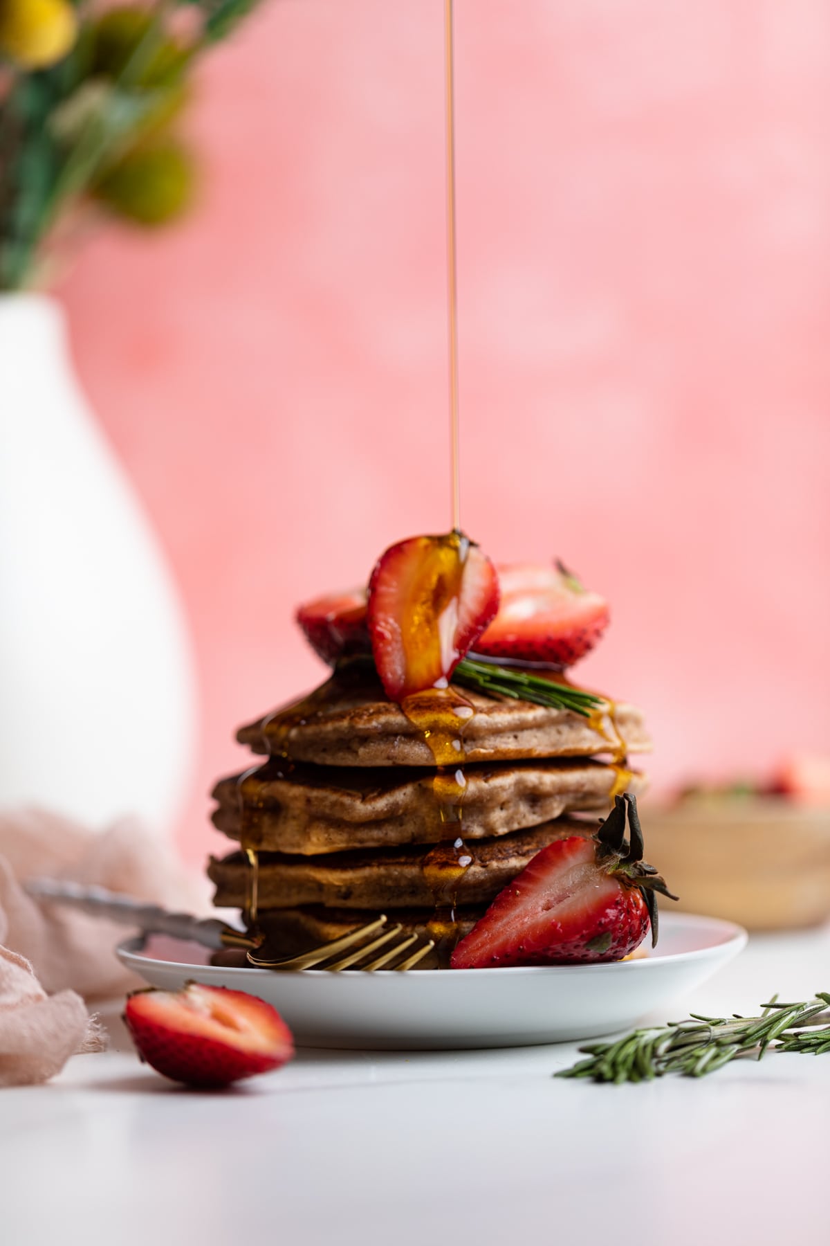 Syrup pouring onto a stack of Whole Wheat Strawberry Pancakes.