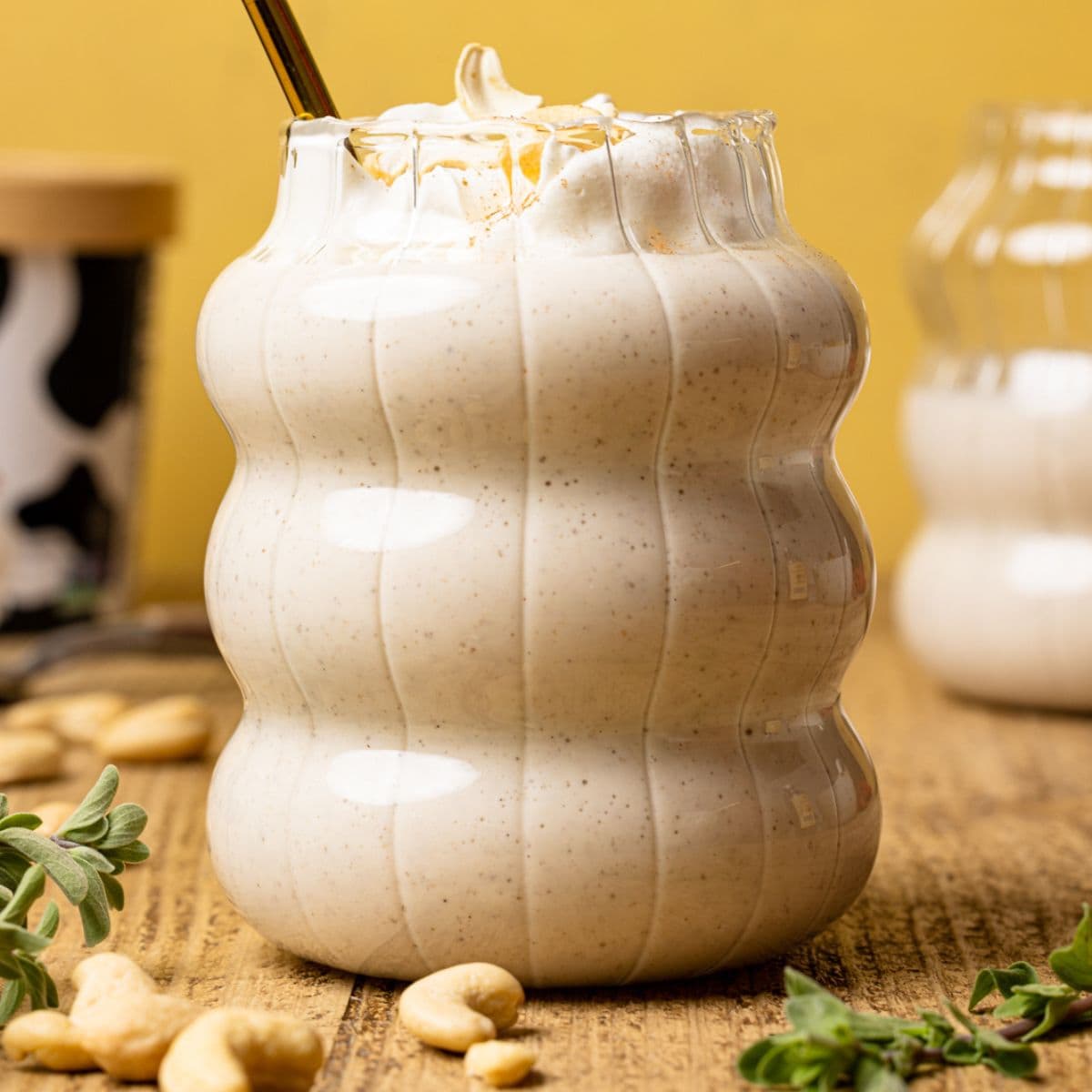 Up close shot of shake in a glass with herbs and cashews.