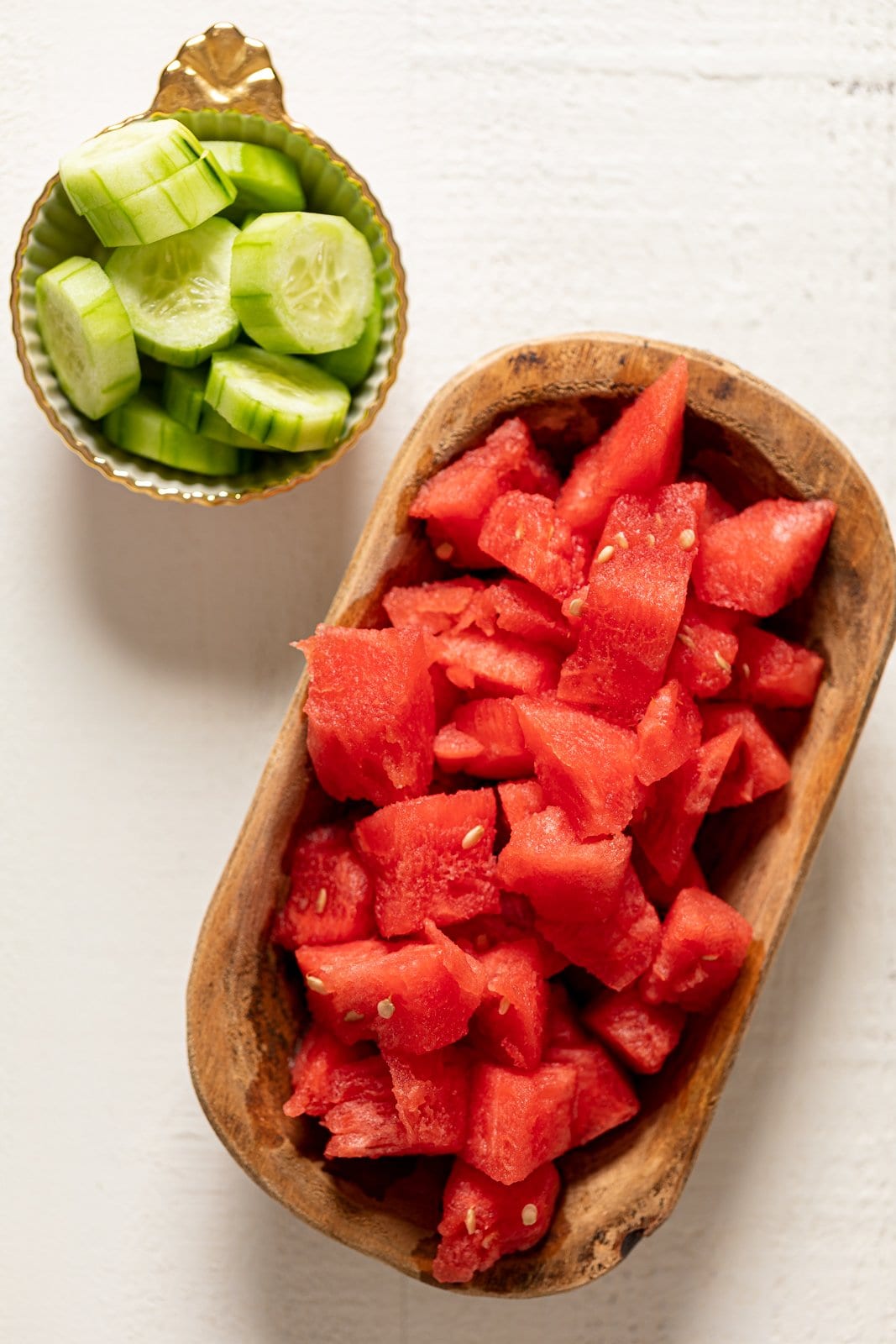 Bowls of cut watermelon and cucumber.