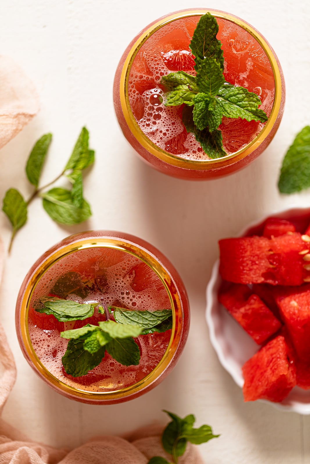 Two gold-rimmed glasses of Fresh Watermelon Cucumber Mint Juice.