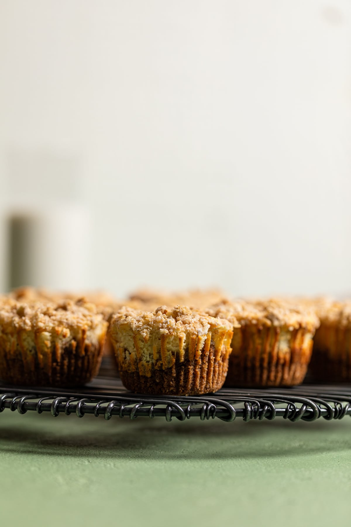 Mini Salted Caramel Apple Streusel Cheesecake Bites on a circular wire rack.