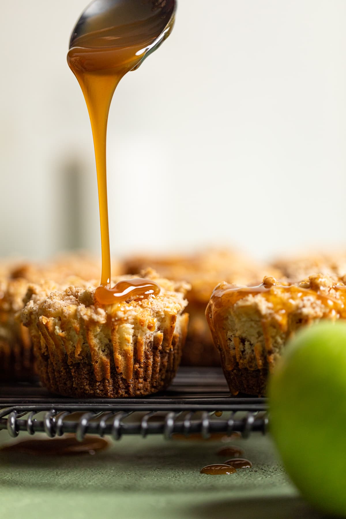 Caramel drizzling onto a Mini Salted Caramel Apple Streusel Cheesecake Bite.