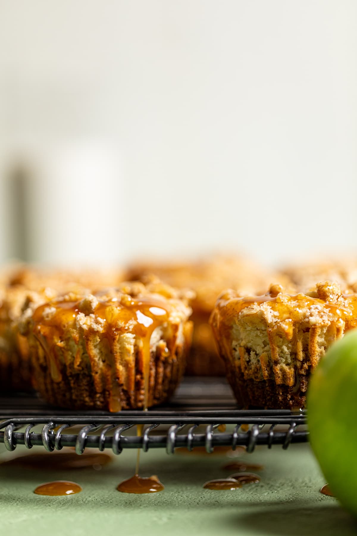 Mini Salted Caramel Apple Streusel Cheesecake Bites topped with salted caramel.