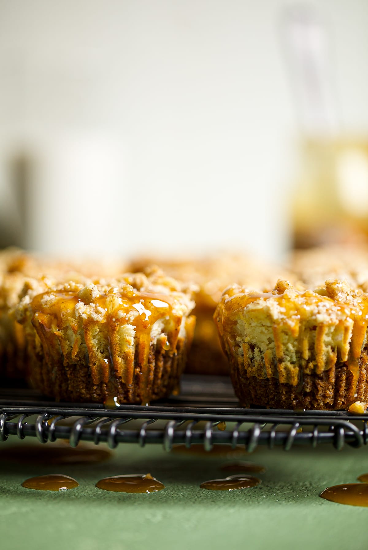 Mini Salted Caramel Apple Streusel Cheesecake Bites topped with salted caramel.