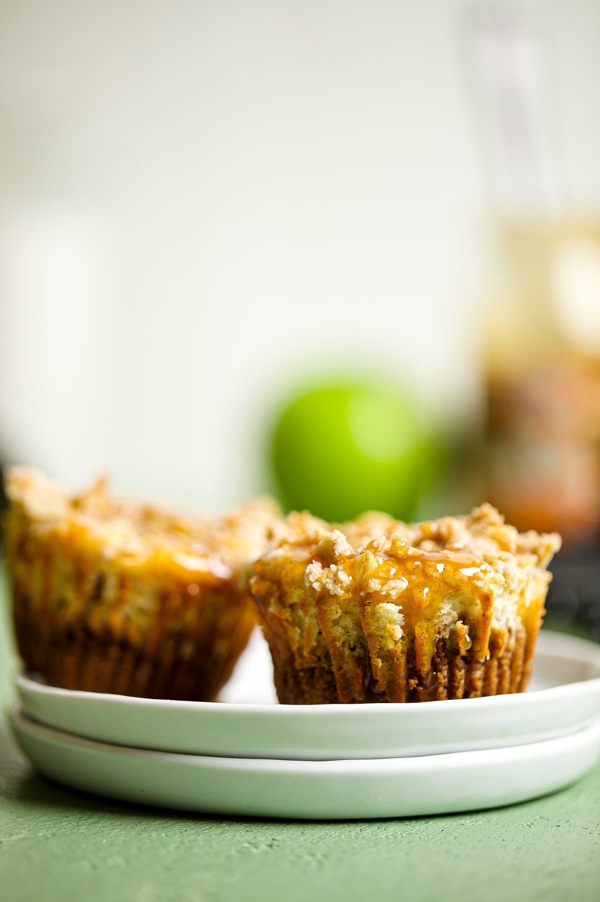 Two Mini Salted Caramel Apple Streusel Cheesecake Bites on small plates.