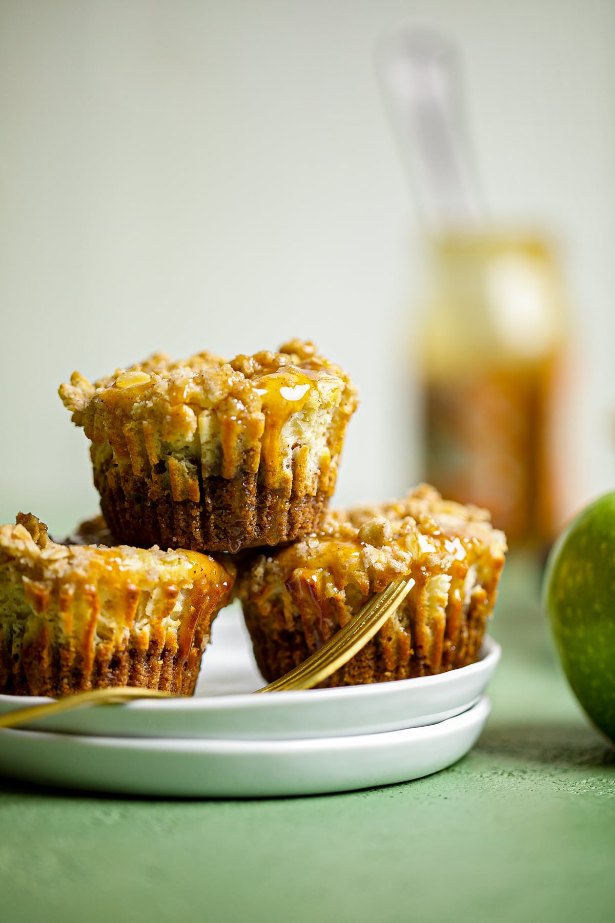 Mini Salted Caramel Apple Streusel Cheesecake Bites piled on plates with a fork.