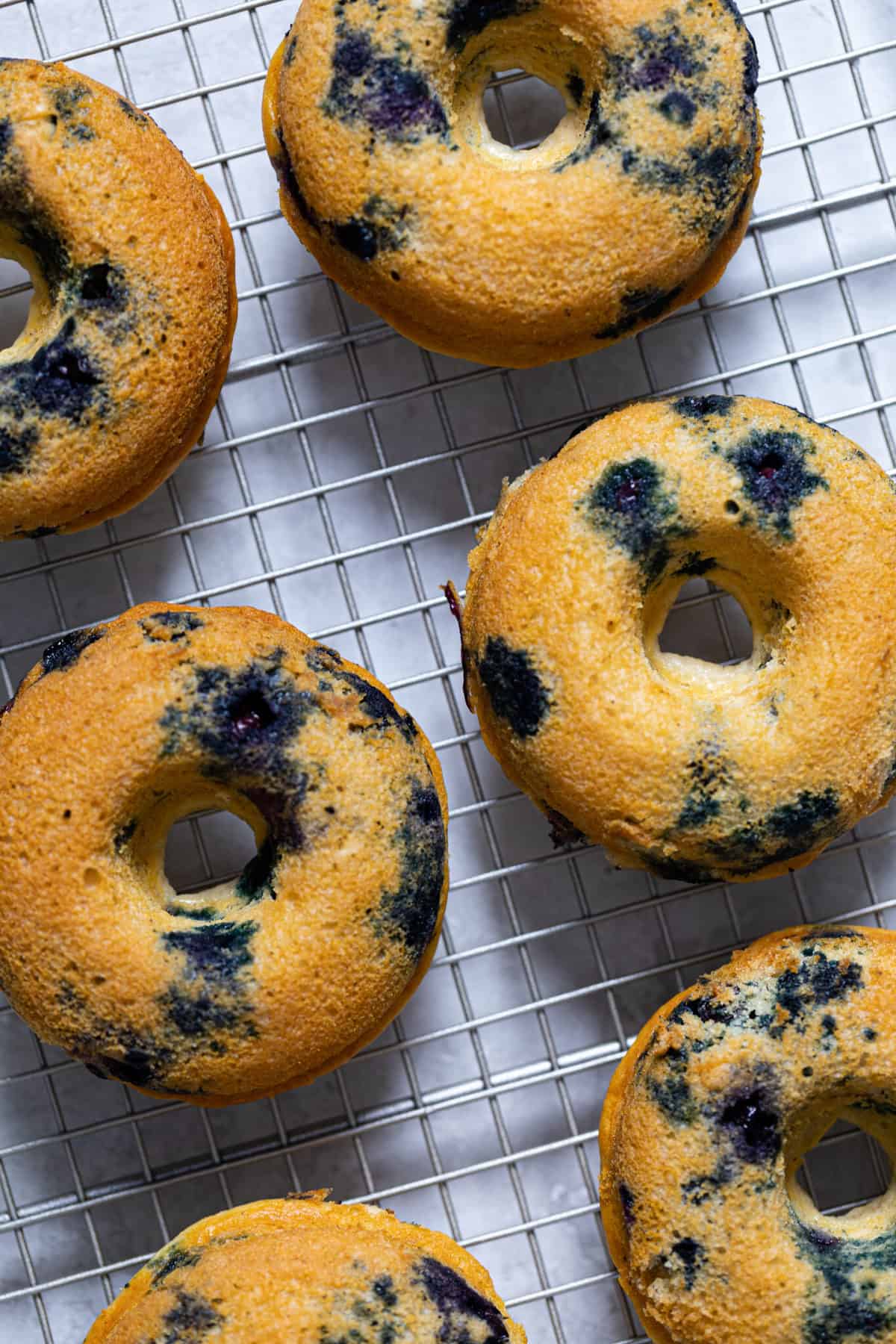 Blueberry Vegan Donuts on a wire rack.