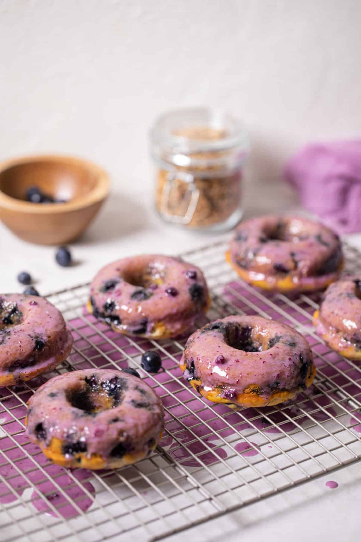 Wire rack topped with Blueberry Vegan Donuts with Blueberry Glaze.