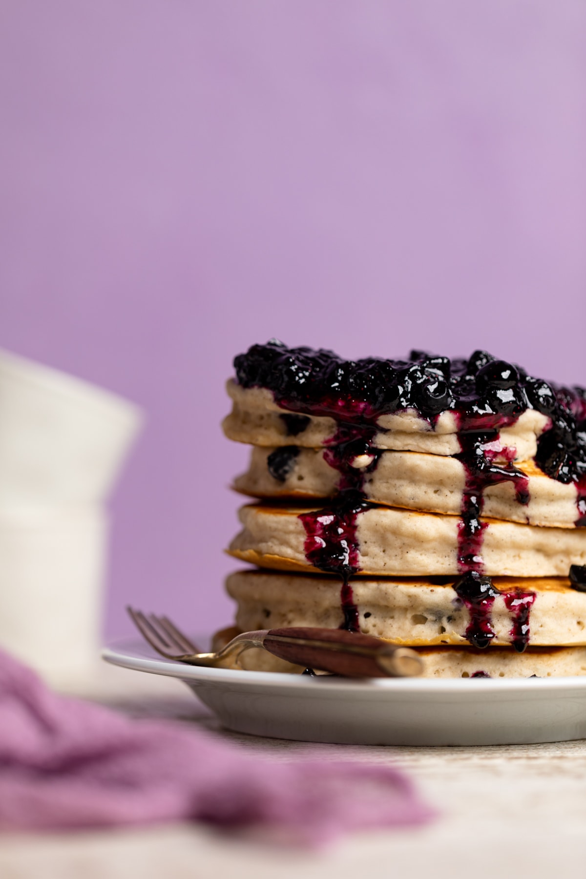 Stack of Dairy-Free Almond Blueberry Pancakes on a plate with a fork