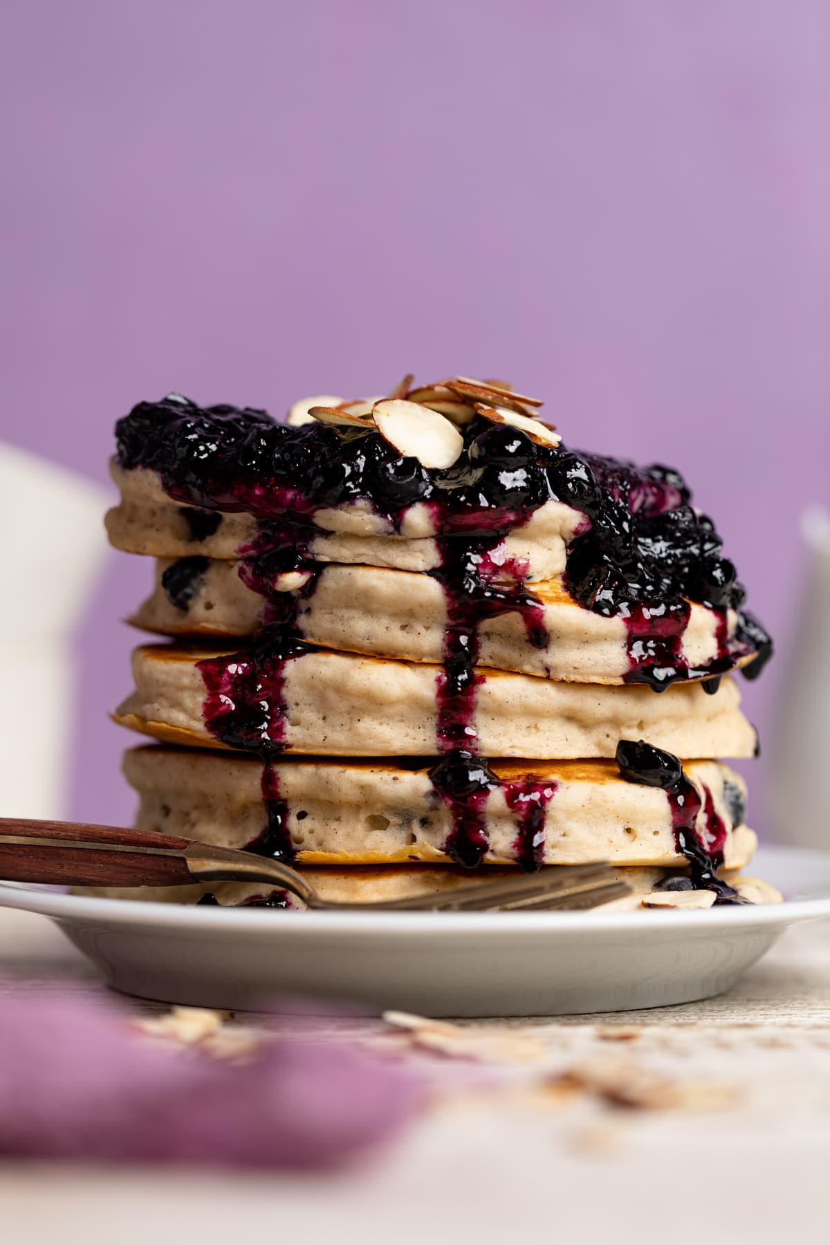 Stack of Dairy-Free Almond Blueberry Pancakes dripping with blueberry topping