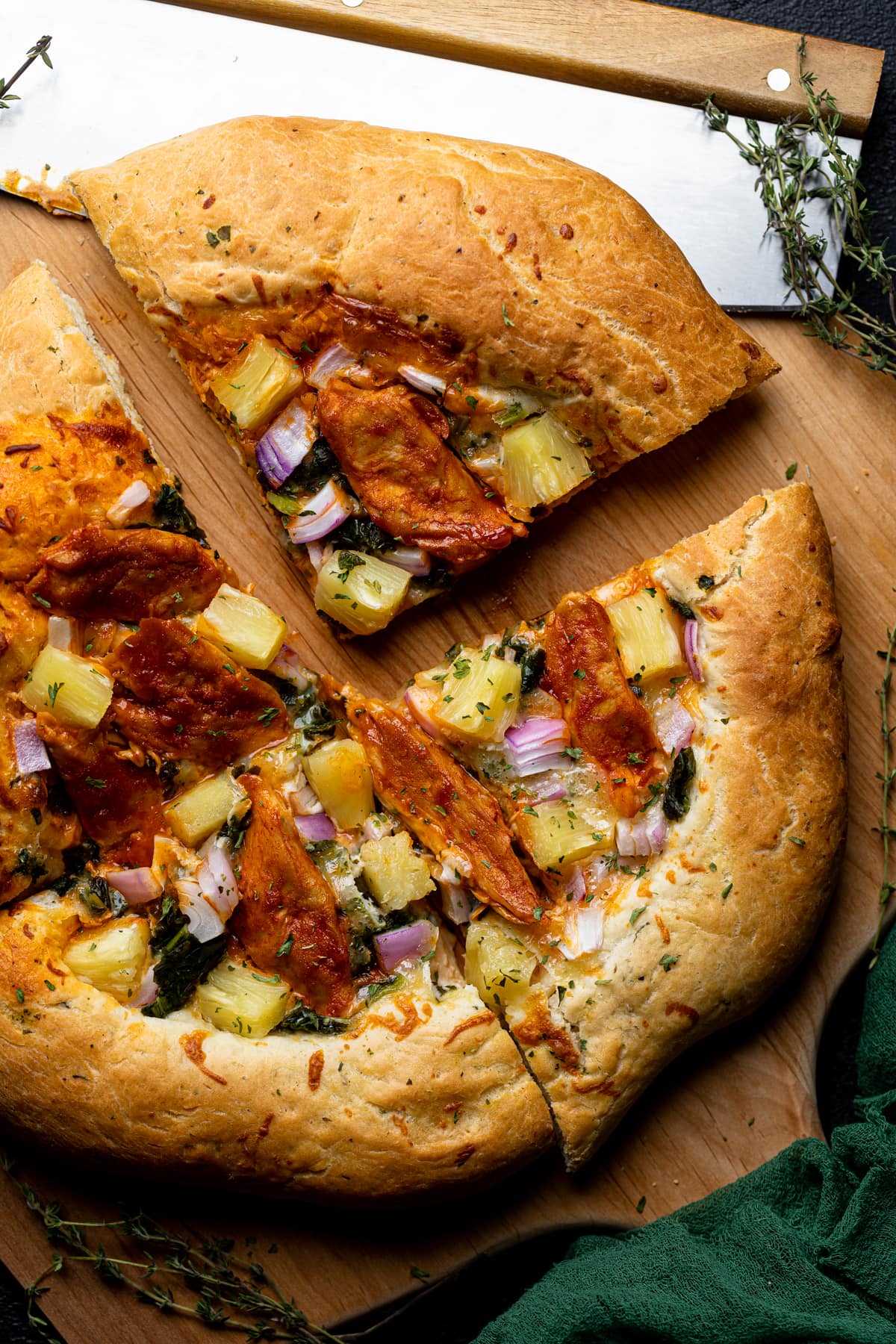 Four slices of Plant-based Hawaiian Buffalo 'Chicken' Pizza. 