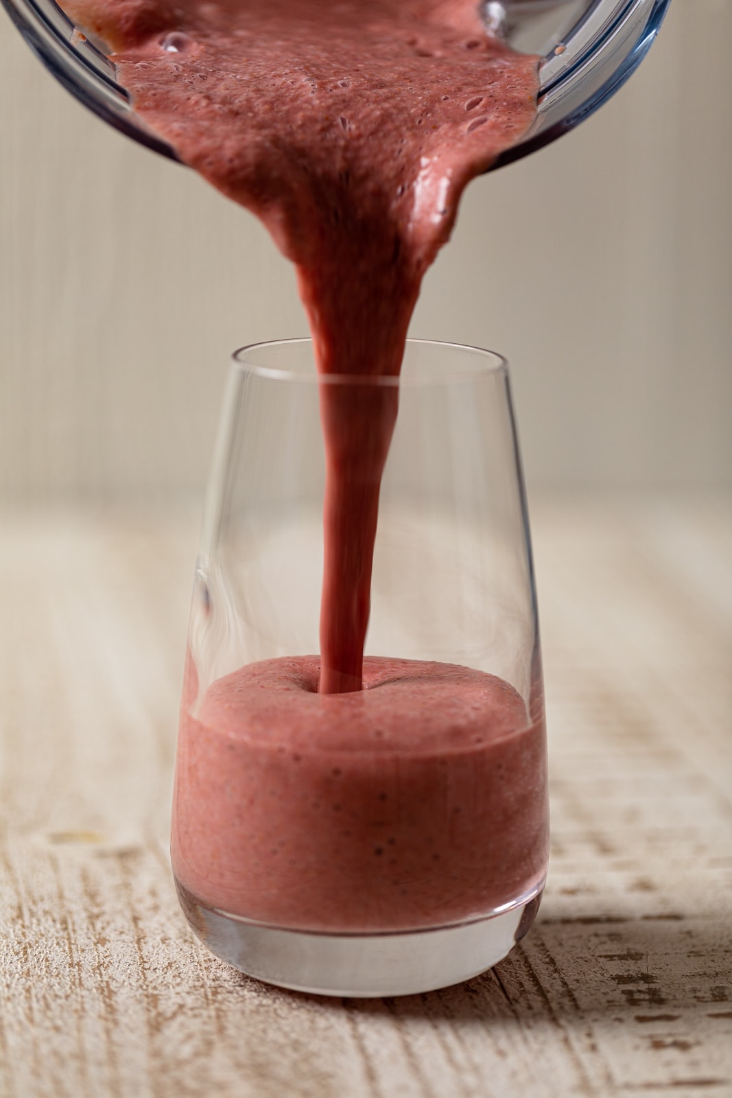 Raspberry ‘Sunrise’ Smoothie pouring into a tall glass.