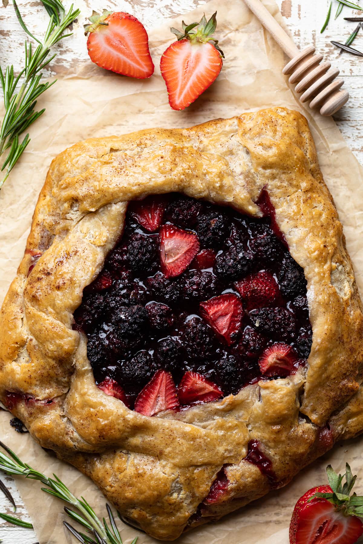 Vegan Berry Galette on parchment paper with garnishes.