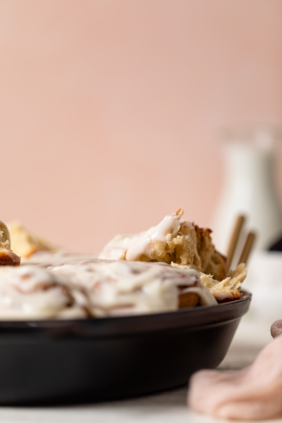 Cinnamon Roll partially pulled out of a baking dish.