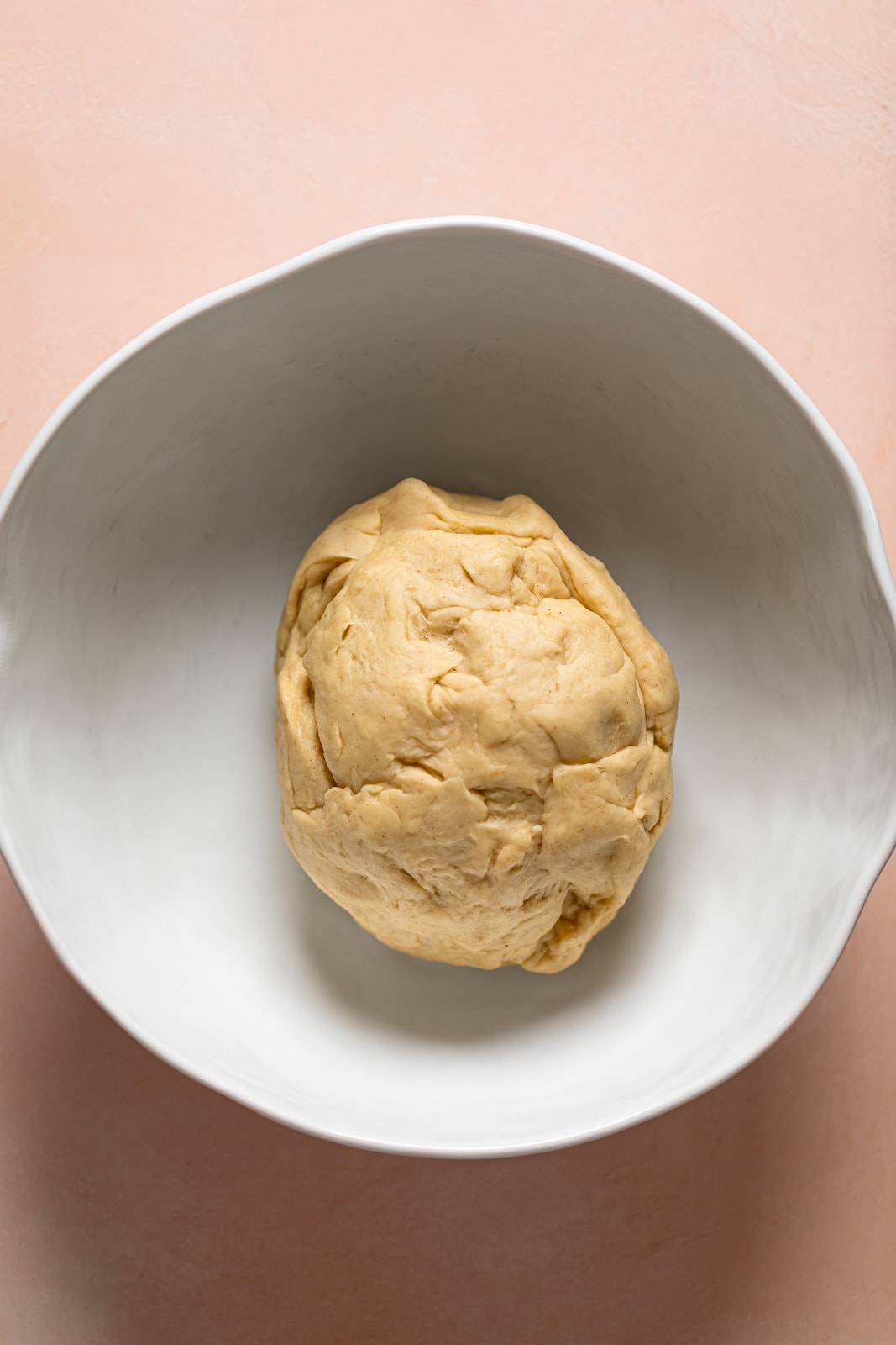 Ball of cinnamon roll dough in a bowl.