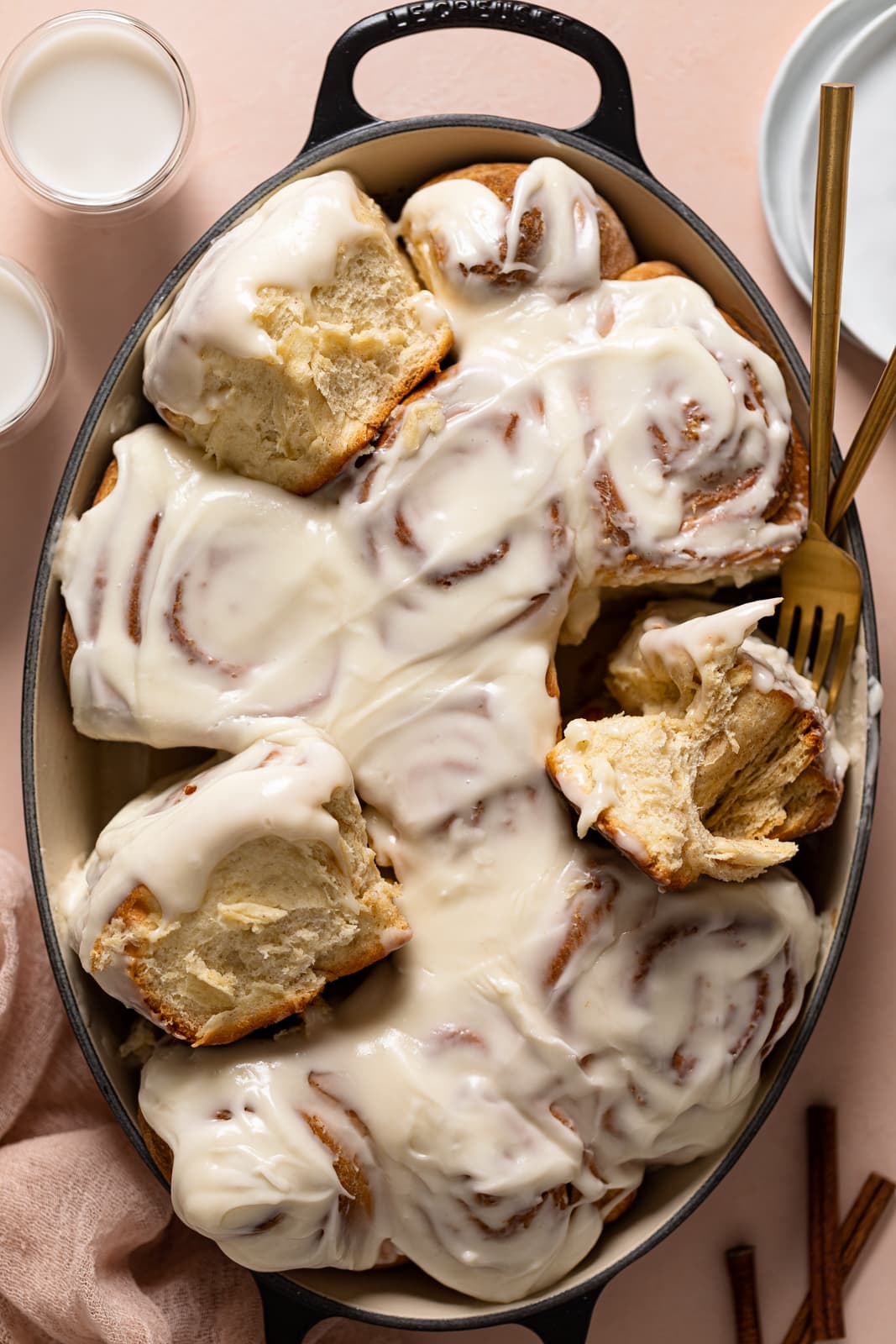 Iced Cinnamon Rolls in a baking dish with a fork.