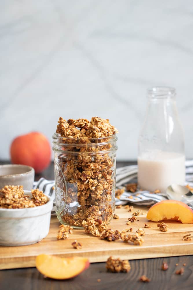 Caramelized Peach Cinnamon Breakfast Granola in a glass jar.