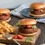 Spicy Barbeque Lentil Quinoa Vegan Burgers with fries on a wooden board.