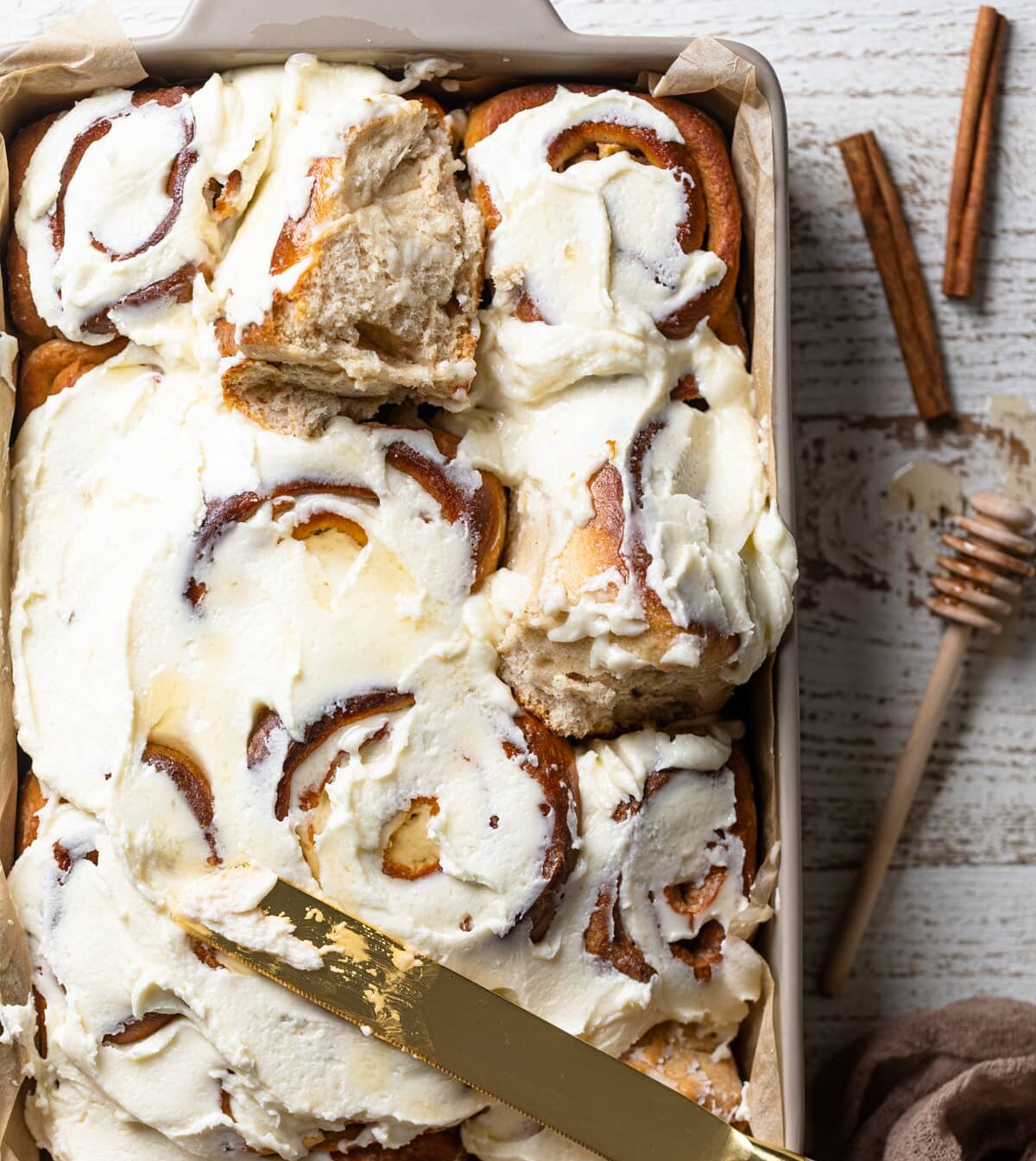 Butter knife of a baking dish of Overnight Vegan Apple Cinnamon Rolls