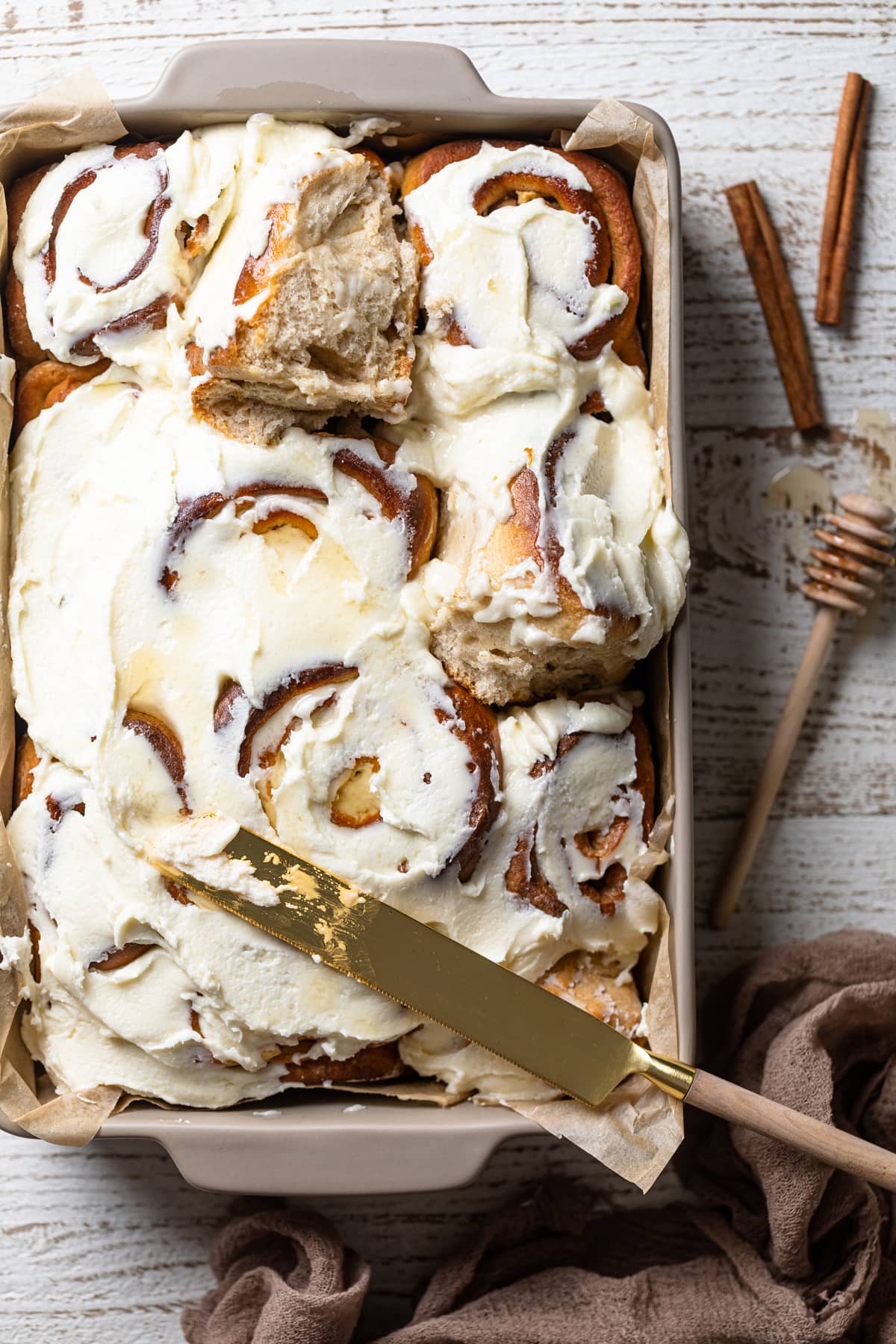 Butter knife of a baking dish of Overnight Vegan Apple Cinnamon Rolls