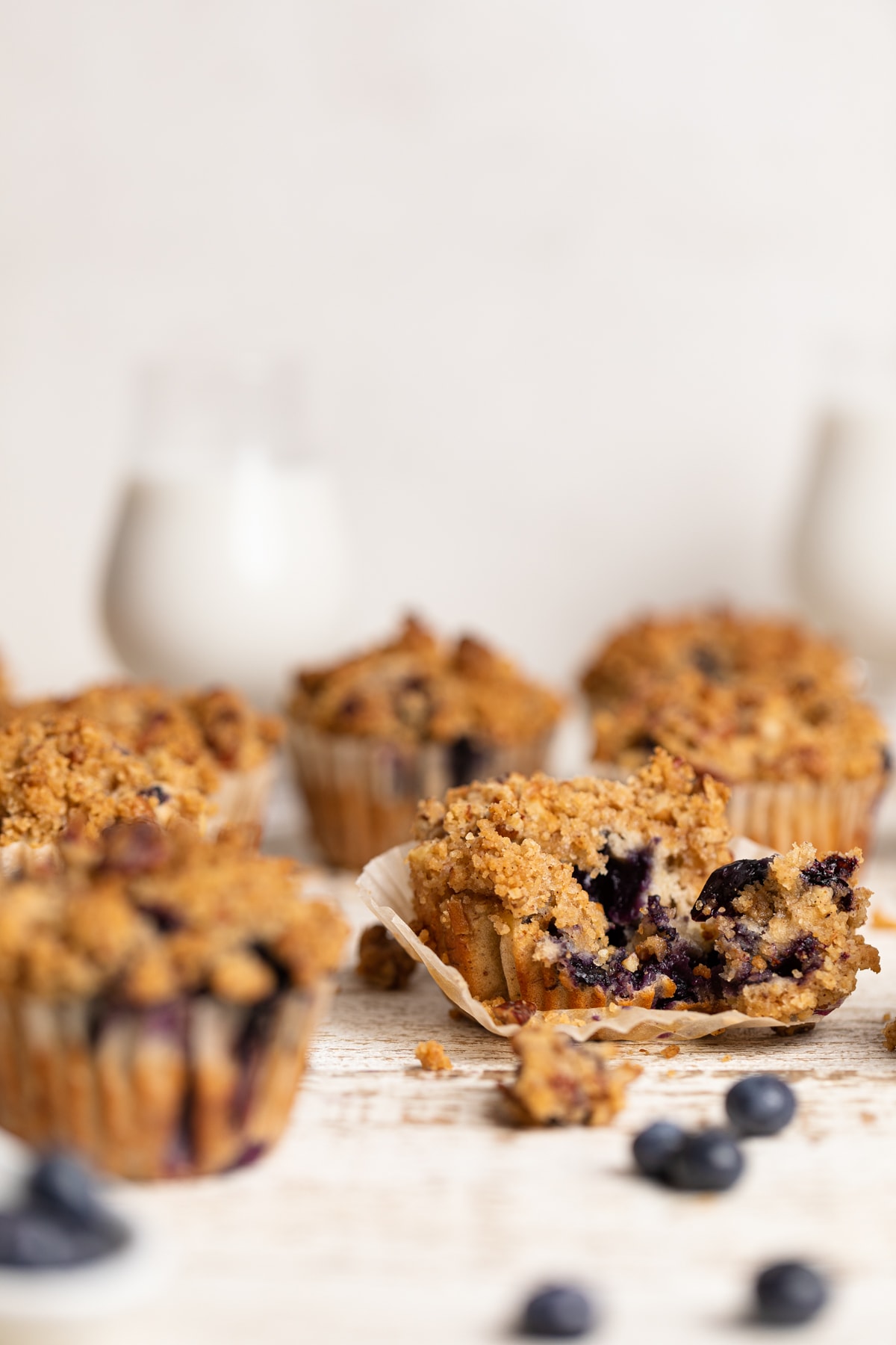 Vegan Banana Blueberry Pecan Crumble Muffins on a white, wooden table
