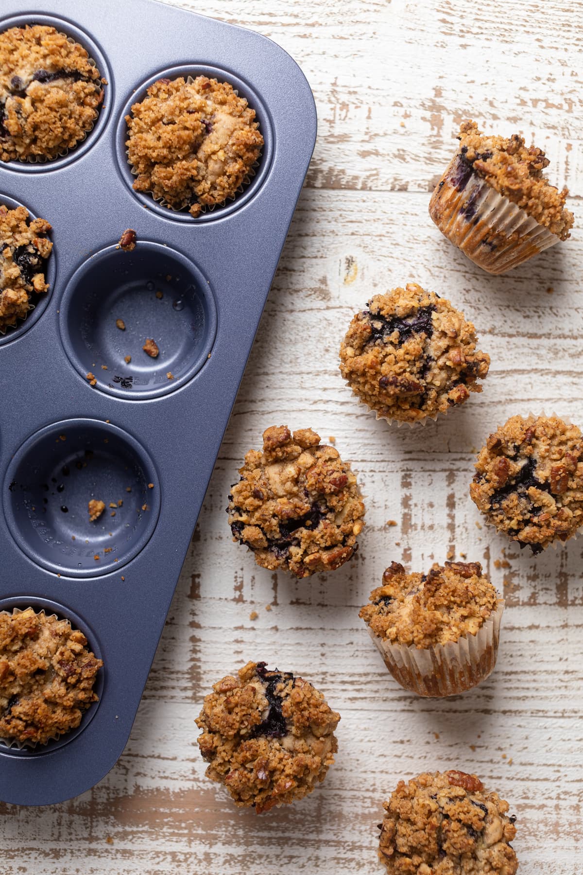 Vegan Banana Blueberry Pecan Crumble Muffins in and out of a muffin pan