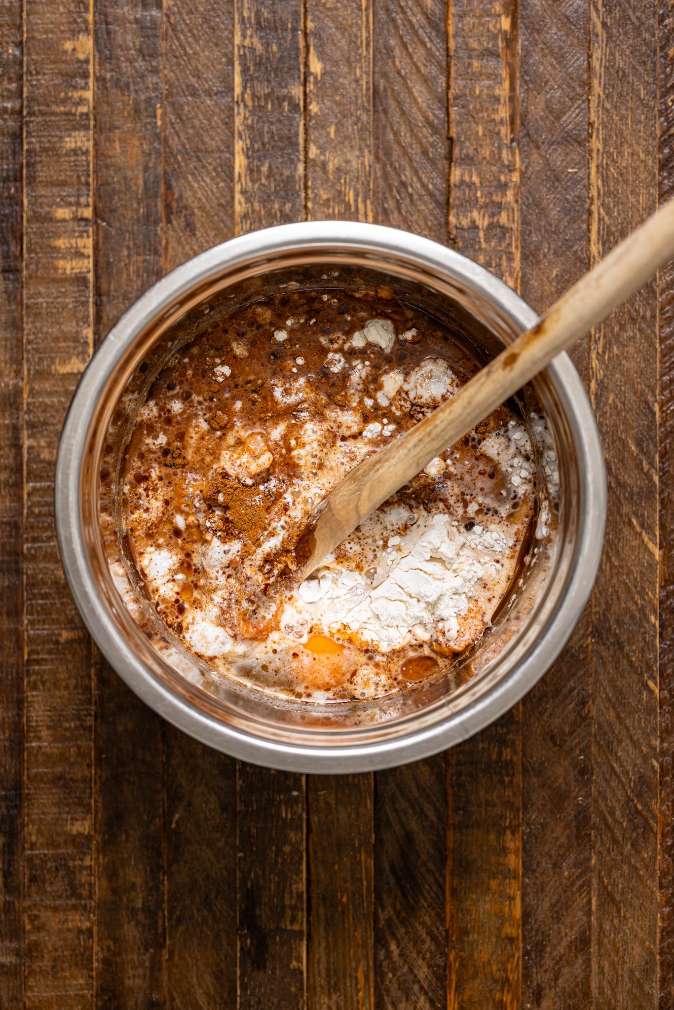 Ingredients together in a silver bowl with a wooden spoon.