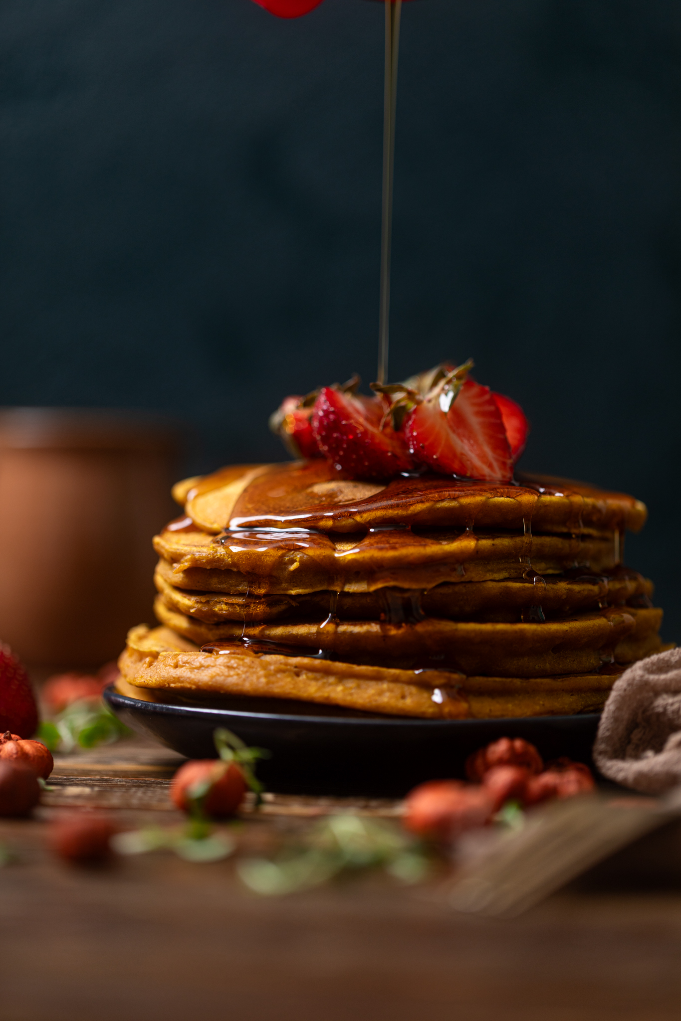 Stack of Cozy Pumpkin Spice Pancakes with syrup being poured on.