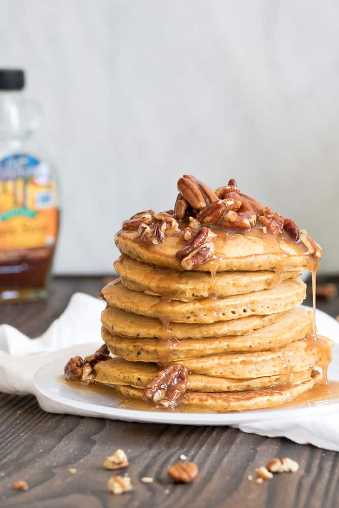Stack of pumpkin quinoa pancakes with praline syrup.
