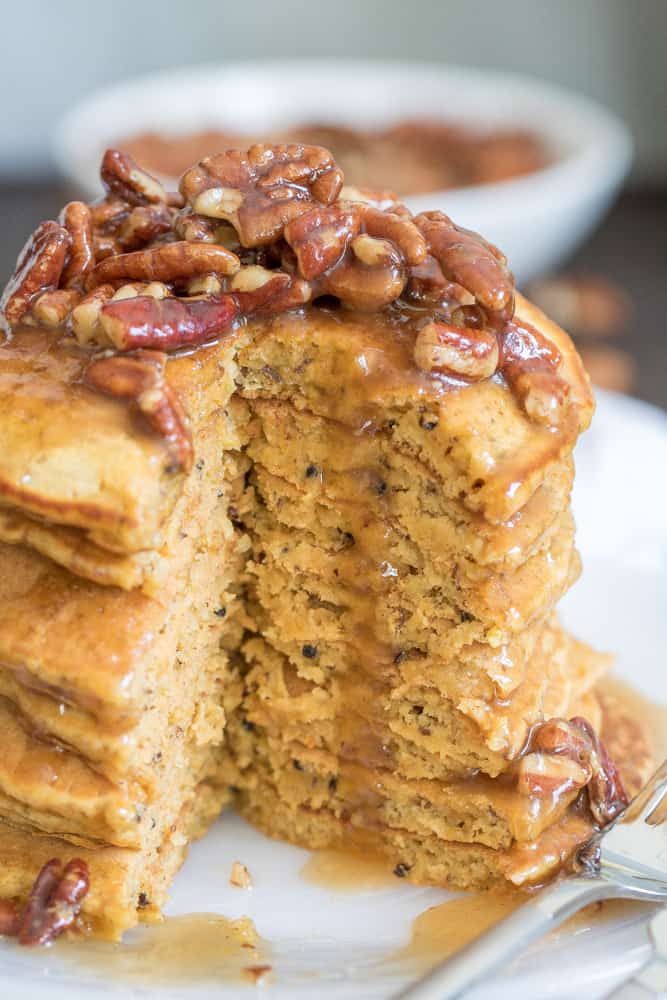 Stack of Pumpkin Quinoa Pancakes with Praline Syrup missing a slice.