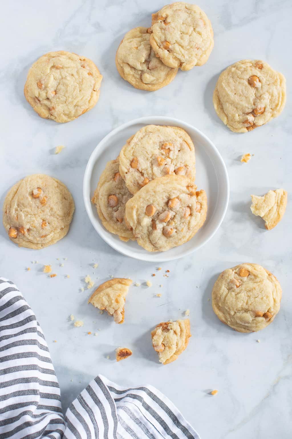 Plate of Soft and Crisp Crinkled Butterscotch Cookies surrounded by broken and whole cookies.