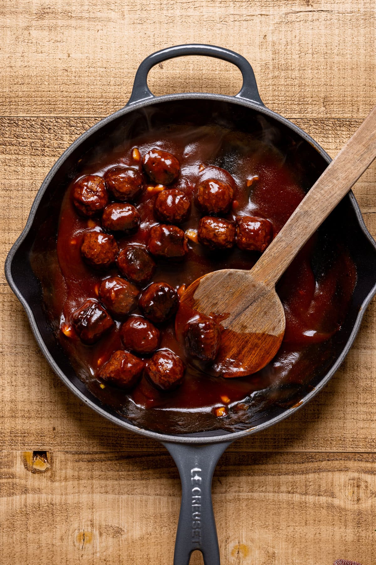 cast iron skillet of vegan meatballs in sauce