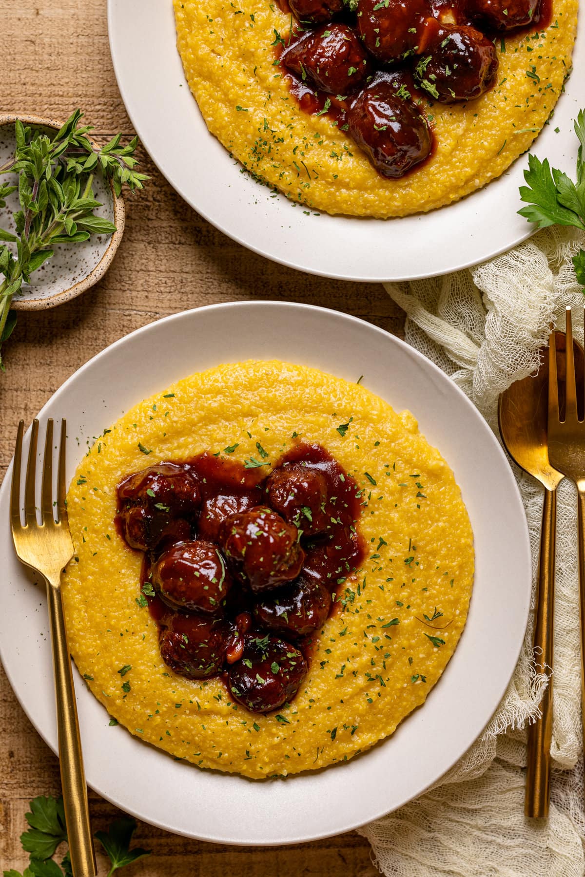 Overhead shot of a two plates of Vegan BBQ Chickpea Meatballs with Polenta