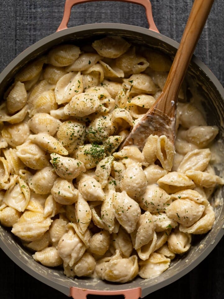 Wooden spoon stirring a pan of Vegan Mac and Cheese